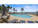 Large community pool with palm trees, lounge chairs, and umbrellas offer relaxation and waterfront views at 6083 Bahia Del Mar Cir # 359, St Petersburg, FL 33715