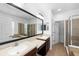 Bathroom featuring double sinks, framed mirror, tiled floors, separate shower, and tub at 6157 Castleton Hollow Rd, Riverview, FL 33578