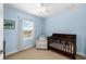 bedroom painted light blue with light colored carpets and a toddler crib at 6157 Castleton Hollow Rd, Riverview, FL 33578