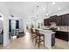 This kitchen features a breakfast bar, stainless appliances, pendant lighting, and smooth flow into the adjacent living spaces at 6157 Castleton Hollow Rd, Riverview, FL 33578