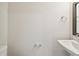 Compact bathroom with a sleek pedestal sink, modern fixtures, and minimalist design at 7266 Kodiak Ln, Sarasota, FL 34240
