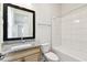 Bright bathroom featuring a granite countertop, modern fixtures, and a tub with white tile surround at 7266 Kodiak Ln, Sarasota, FL 34240