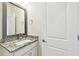 Powder room featuring a granite countertop, modern mirror, and door at 7266 Kodiak Ln, Sarasota, FL 34240