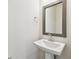 Modern bathroom featuring a white pedestal sink with chrome fixtures and simple wall decor at 7266 Kodiak Ln, Sarasota, FL 34240