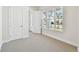Well-lit bedroom with neutral carpet, white trim, and large windows offering a neighborhood view at 7266 Kodiak Ln, Sarasota, FL 34240
