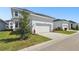 A clean two-car garage with a concrete driveway, small landscaping, and white exterior walls under a clear, sunny sky at 7266 Kodiak Ln, Sarasota, FL 34240