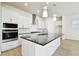 Modern kitchen with stainless steel appliances, white cabinetry, and a large center island with dark countertops at 7266 Kodiak Ln, Sarasota, FL 34240