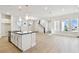 Open-concept kitchen featuring a large island, stainless steel appliances, and an adjacent living area at 7266 Kodiak Ln, Sarasota, FL 34240