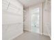 Large walk-in closet connected to the bathroom with shelving and neutral carpeting at 7266 Kodiak Ln, Sarasota, FL 34240