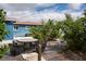 The backyard includes an outdoor dining set, mature plantings, and a small patio at 10754 111Th N Pl, Largo, FL 33778