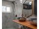 Bathroom featuring dual hammered copper bowl sinks on a wood counter and tile walls at 10754 111Th N Pl, Largo, FL 33778