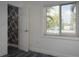 Bright bedroom features wood-look flooring, closet with striking black-and-white wallpaper, and a sunlit window at 10754 111Th N Pl, Largo, FL 33778
