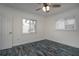 Bright bedroom with new flooring, two windows with blinds and a view of the front yard at 10754 111Th N Pl, Largo, FL 33778