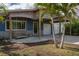 Charming single-story home featuring a covered carport and inviting porch with a comfortable swing for relaxation at 10754 111Th N Pl, Largo, FL 33778