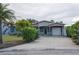 Blue single-story home boasts a covered carport with a driveway, offering ample parking and protection from the elements at 10754 111Th N Pl, Largo, FL 33778