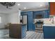 Modern kitchen with stainless steel appliances and blue cabinetry with copper hardware at 10754 111Th N Pl, Largo, FL 33778