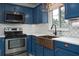 Up close view of kitchen featuring stainless steel oven and microwave, copper sink and white backsplash at 10754 111Th N Pl, Largo, FL 33778