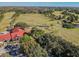 Expansive aerial view of a golf course and clubhouse nestled among mature trees and lush fairways at 10814 Brickside Ct, Riverview, FL 33579