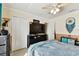 Bedroom with a large television, ceiling fan, blue curtains, and two closets at 10814 Brickside Ct, Riverview, FL 33579