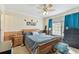 Bedroom with a wooden bed frame, blue curtains, ceiling fan, and musical note decor at 10814 Brickside Ct, Riverview, FL 33579