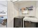 Laundry closet with a dark gray washer and white dryer, and a shelf with supplies at 10814 Brickside Ct, Riverview, FL 33579