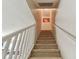 Carpeted stairs leading to the upper level of the home, featuring white railings and a textured wall finish at 10814 Brickside Ct, Riverview, FL 33579