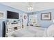 Airy bedroom with blue walls, a ceiling fan, large flat screen tv, and a comfortable patterned quilt at 12162 Aurora Ct, Largo, FL 33774