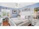 Serene blue bedroom featuring a large bed, a ceiling fan, and decor with equestrian artwork at 12162 Aurora Ct, Largo, FL 33774