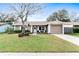 Charming single-story home featuring a well-manicured lawn and a cozy front porch with seating at 12162 Aurora Ct, Largo, FL 33774