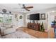 Bright living room with a large television, front door, leather furniture, and decorative accents for a modern feel at 12162 Aurora Ct, Largo, FL 33774