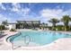 Beautiful pool with a covered seating area, palm trees, and clear blue water for relaxation and enjoyment at 12315 51St E St, Parrish, FL 34219