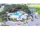 Aerial view of community clubhouse and pools with tennis courts, mature trees, parking, and splash pad at 13006 Tidal Flats Loop, Riverview, FL 33579