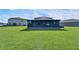 Backyard view showcasing a screened lanai and ample green space for outdoor activities at 13006 Tidal Flats Loop, Riverview, FL 33579