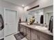 Bathroom featuring double sinks with granite countertop, dark cabinets and a large mirror, offering ample counter space at 13006 Tidal Flats Loop, Riverview, FL 33579