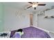Bedroom showcasing a white bed with purple bedding, a personalized 'Riley' wall decor, and minimalist floating shelves at 13006 Tidal Flats Loop, Riverview, FL 33579