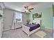 Bedroom featuring a white bed with purple bedding, a light green accent wall and a window with natural light at 13006 Tidal Flats Loop, Riverview, FL 33579