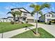Inviting two-story home boasts a lush green lawn, ample parking space, mature landscaping and shade trees at 13006 Tidal Flats Loop, Riverview, FL 33579