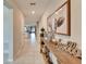 A hallway with a shelf and decorative items lead to a living area and a nearby closed white door at 13006 Tidal Flats Loop, Riverview, FL 33579