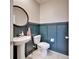 Stylish powder room with a sleek pedestal sink, modern fixtures, and decorative wall paneling at 13006 Tidal Flats Loop, Riverview, FL 33579