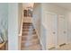 Carpeted staircase with white railing, showcasing a clean and simple design with neutral walls and a view of the upper level at 13006 Tidal Flats Loop, Riverview, FL 33579