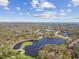 Overhead view of a serene lake amidst a vibrant community and mature trees at 1301 Melonwood Ave, Clearwater, FL 33759