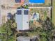 Aerial view of a home featuring solar panels, a backyard patio, and a spacious, tree-lined lot at 1301 Melonwood Ave, Clearwater, FL 33759