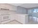 Kitchen featuring tile flooring, white cabinetry, and breakfast bar to a sunroom at 1321 N Mcmullen Booth Rd # 1321, Clearwater, FL 33759
