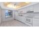 Bright all-white kitchen featuring a window, sleek appliances, and modern countertops at 1321 N Mcmullen Booth Rd # 1321, Clearwater, FL 33759