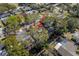 An aerial view showcasing the property's location amidst a neighborhood with lush trees and nearby creek at 1582 Sandalwood Dr, Dunedin, FL 34698