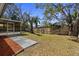 Large backyard with mature trees and a spacious patio area for outdoor enjoyment at 1582 Sandalwood Dr, Dunedin, FL 34698