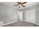 This bedroom features gray walls, woodgrain floors, and a ceiling fan with light at 1582 Sandalwood Dr, Dunedin, FL 34698