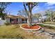 Well-maintained home with lush lawn, mature tree, colorful landscaping, and a two-car garage at 1582 Sandalwood Dr, Dunedin, FL 34698