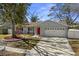 Charming home with a red front door, manicured lawn, and a two-car garage at 1582 Sandalwood Dr, Dunedin, FL 34698