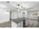 Open-concept kitchen with granite island, wine fridge, recessed lighting, and modern pendant lights at 1582 Sandalwood Dr, Dunedin, FL 34698